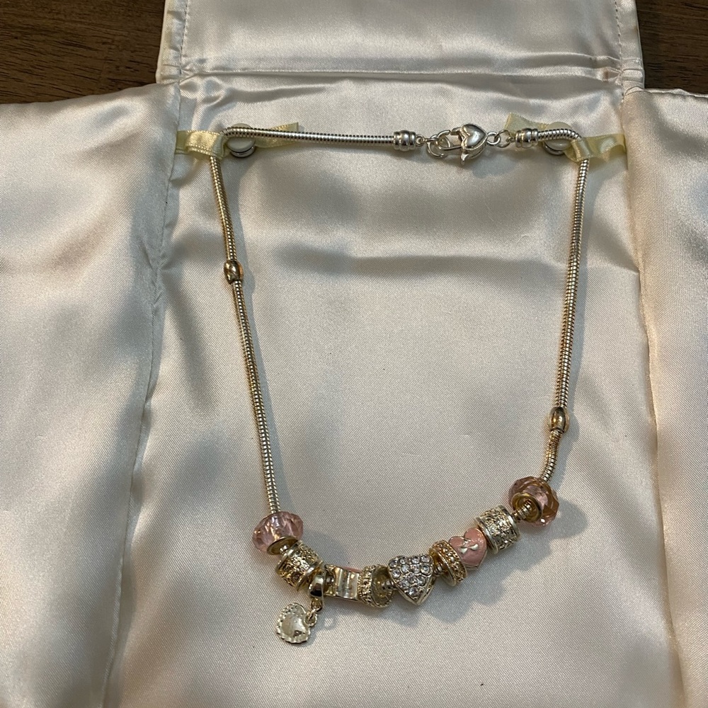 Friedman’s necklace in silver with charms and pink charms. Brand new.